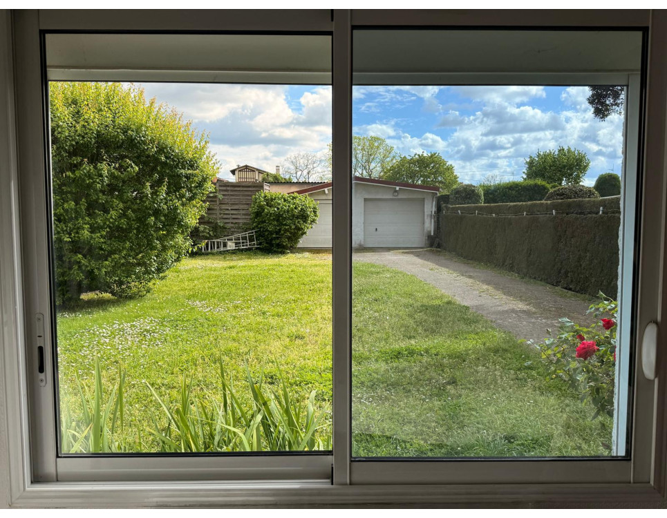 Comparaison d'une vitre avec et sans film anti-chaleur transparent pour fenêtre, vue sur un jardin